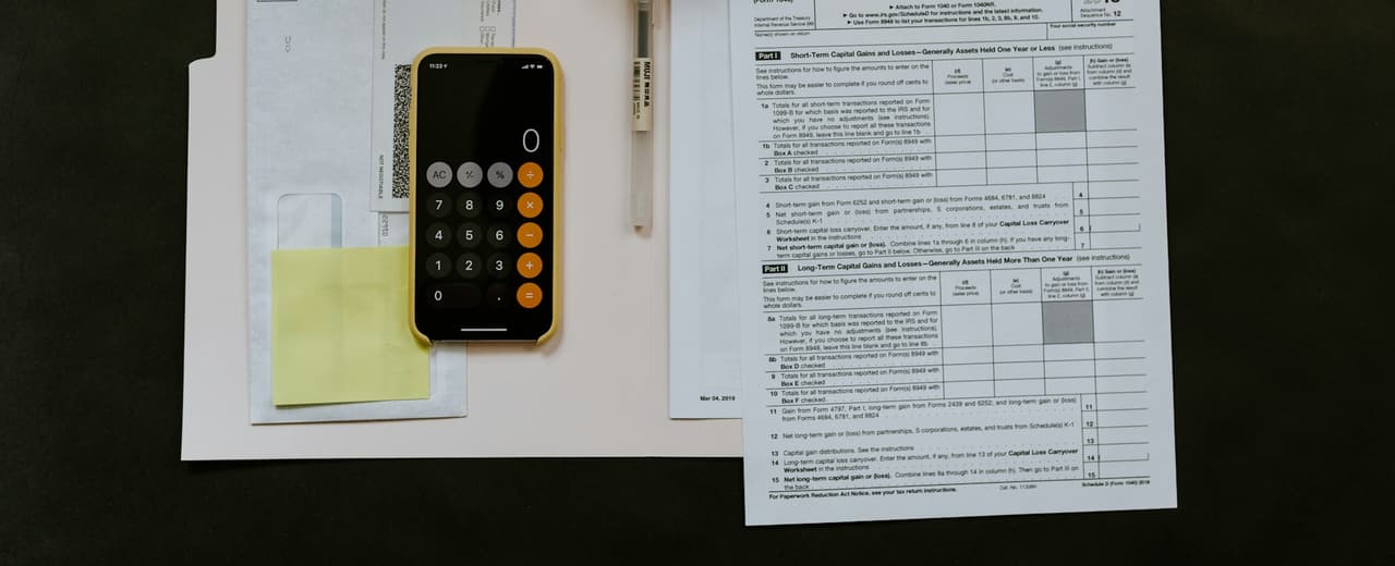A person reviewing paperwork and a calculator