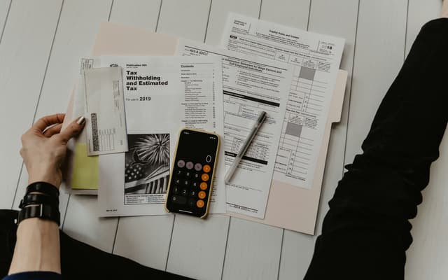 Printed documents and a calculator spread across a desk