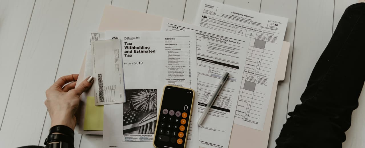 Printed documents and a calculator spread across a desk