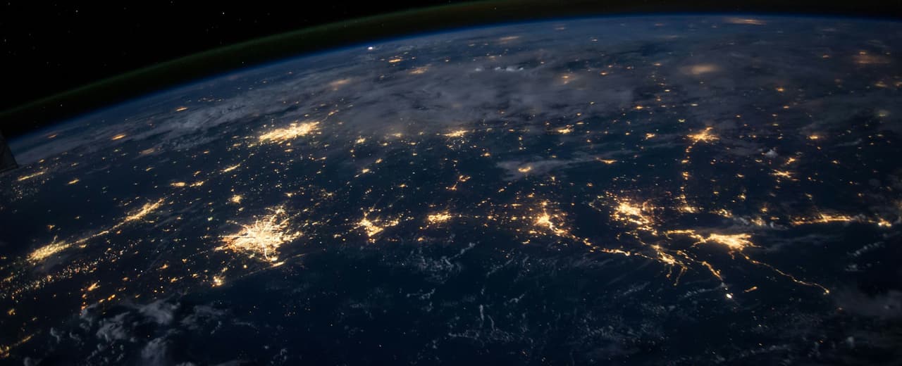 The Earth at night seen from orbit, city lights visible