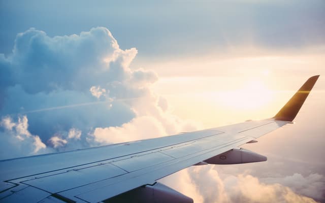 An aircraft wing above the clouds