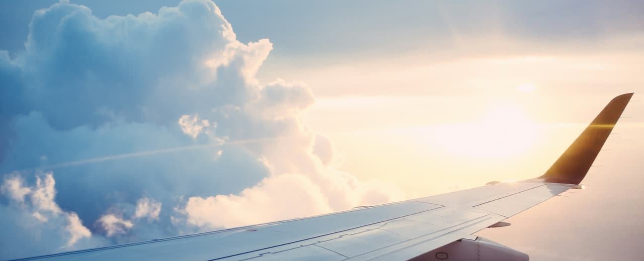 An aircraft wing above the clouds