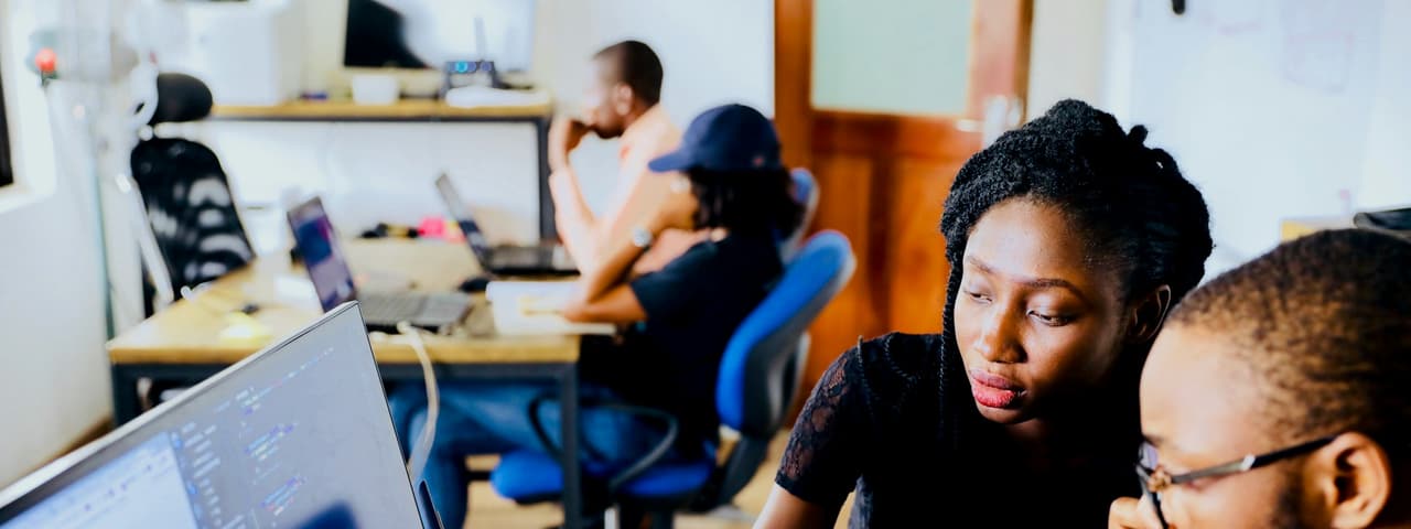 Several people working on laptops in a shared workspace
